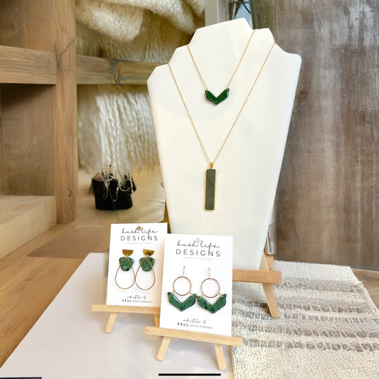 Jewelry set with necklaces and earrings on a mannequin and display stand.